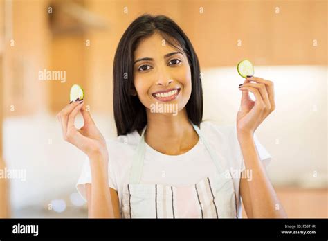 Happy Indian Girl Holding Slices Of Cucumber In Kitchen Stock Photo Alamy