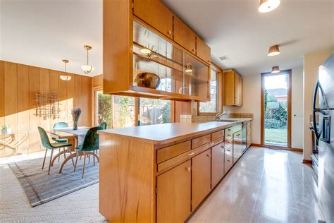 A Large Kitchen With Wooden Cabinets And Stainless Steel Appliances