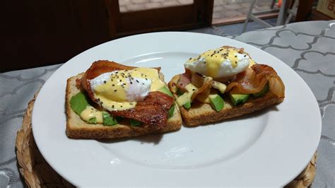 Poached Eggs On Bacon Avocado And Toast Topped With A Hollandaise