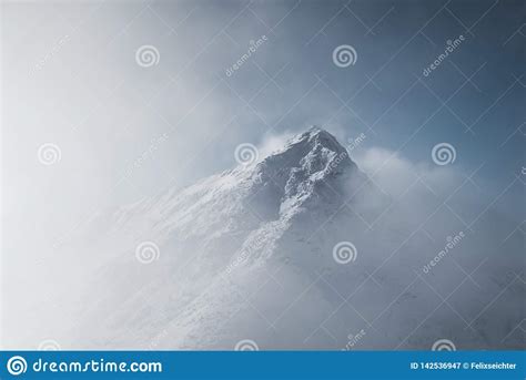 Snowy Mountain Peak On A Sunny Day With Avalanches On The Slope Stock