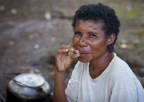 Woman With Earrings Made With Turtle Shells Smoking Milne Bay Province