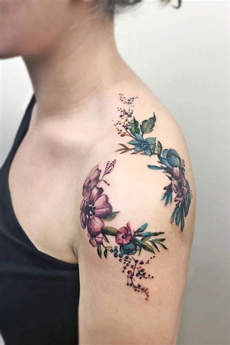 A Womans Shoulder With Flowers On It And Leaves In The Middle Of Her Arm