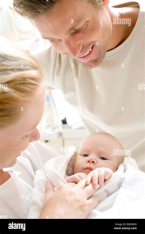 Parents And Newborn Baby Mother And Father In A Maternity Ward Holding