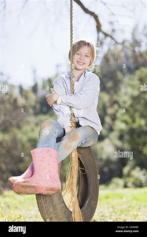 Girl Sitting On Tire Swing Outdoors Stock Photo Alamy