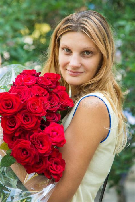 Portrait Of A Beautiful Girl With A Bouquet Of Roses In Her Hands Stock