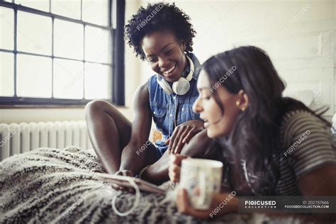 Lesbian Couple Drinking Coffee And Using Digital Tablet On Bed — Food And Drink Bedroom Stock