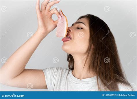 Young Beautiful Woman Licking Slice Of Ham With Her Tongue In Tempting