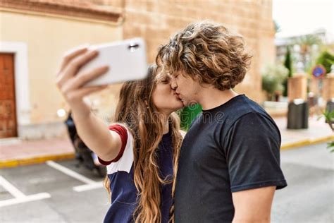 Young Caucasian Couple Kissing And Hugging Make Selfie By The