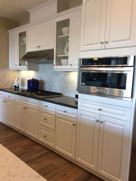 The tan color of the stone pairs well with the dark cabinets and stainless steel appliances. White Kitchen Cabinets, Dark Quartz Countertop | Off white kitchens, Off white kitchen cabinets ...