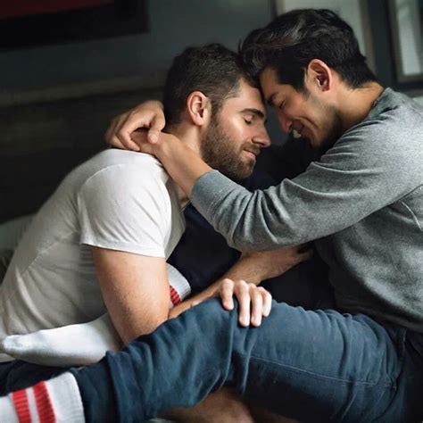 Two Men Hugging Each Other While Sitting On A Couch