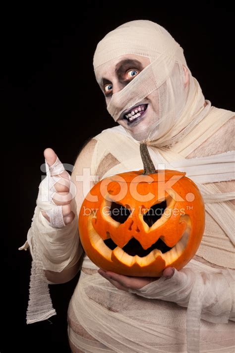 Scary Mummy With Halloween Pumpkin Holding Thumbs Up Stock Photo