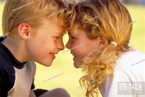 Park Scene Portrait Close Up Profile Blond Curly Girl With Plaits Wearing White T Shirt And