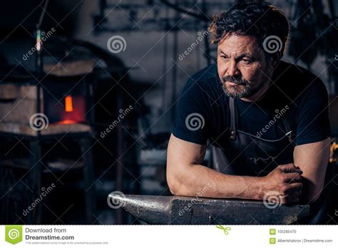 Portrait Of Blacksmith Preparing To Work Metal On The Anvil Stock Photo