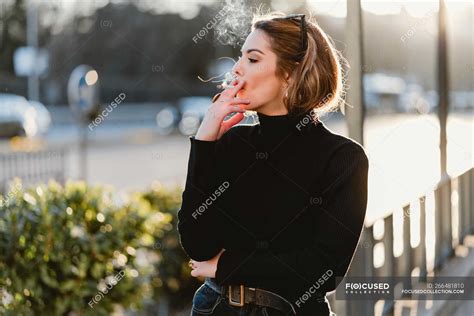 Pretty Woman Smoking Cigarette On Sunny Street — Looking