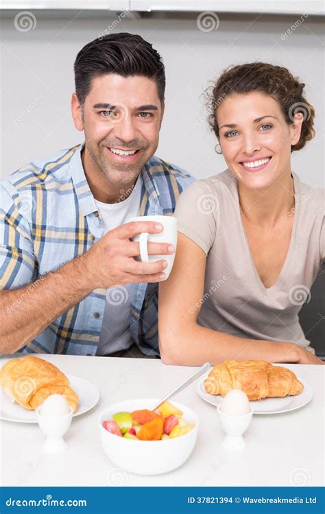 Pares Sonrientes Que Se Sientan Desayunando Junto Foto De Archivo