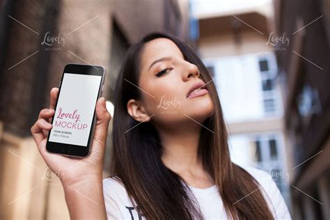 Beautiful Young Woman Holding An Iphone While In The City Lovely Mockups