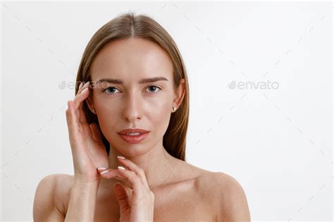 Tender Young Woman Touching Her Perfect Face And Looking At Camera Over