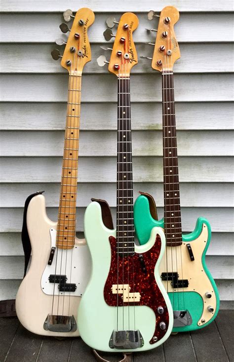 Three Guitars Are Lined Up In Front Of A Wall And One Is Green The