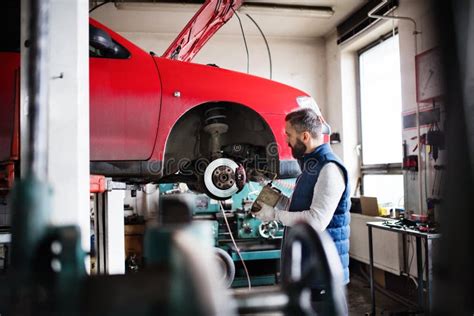 Man Mechanic Repairing A Car In A Garage Stock Photo Image Of Person