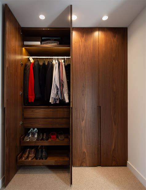 An Open Closet With Shoes And Clothes Hanging On The Wall Next To A
