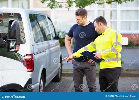 Loss Adjuster With Clipboard Inspecting Damaged Car Stock Photo Image