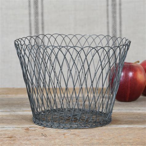A container made of interwoven strips of pliable materials, such as cane, straw, thin wood, or plastic, and often carried by means of a handle or handles 2. HomArt Medium Tulle Wire Basket - AREOhome