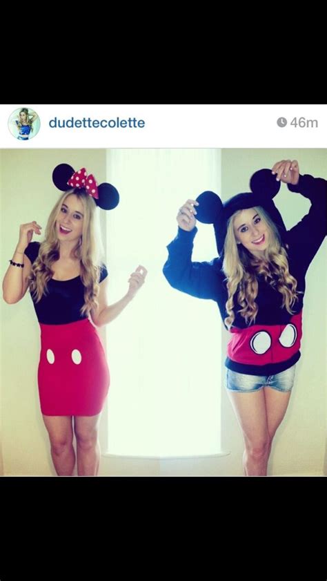two women dressed in mickey mouse costumes posing for a photo with their hands on their hipss