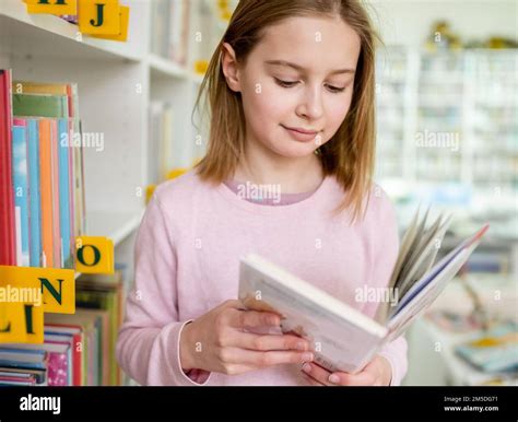 Pretty Girl Child Reading Book In Library Stock Photo Alamy
