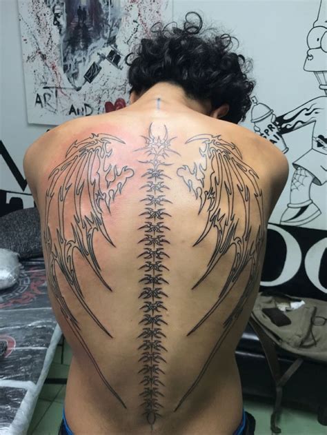 The Back Of A Man With Tattoos On His Body