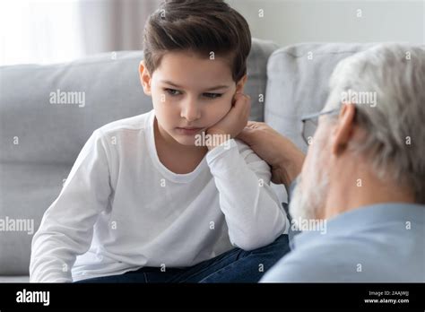 Caring Grandfather Calming Talking With Upset Little Grandson Stock