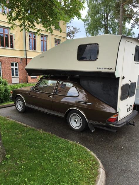 An Rv Parked In Front Of A Building With A Car Under The Awning And A