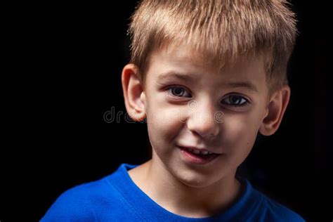 Portrait Of The Boy `s Smiling Child Close Up Against A Black