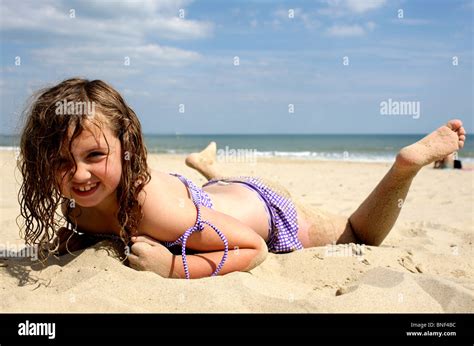glücklich lächelnde junge mädchen im bikini bademode liegen auf sand am strand stockfotografie