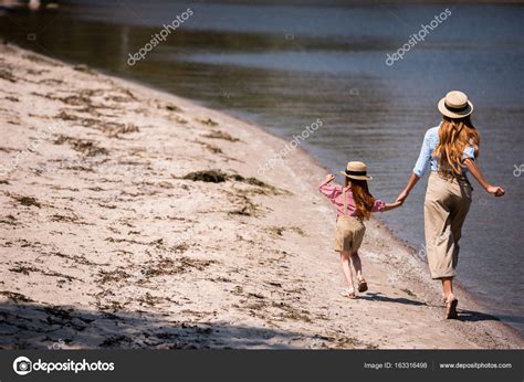 Madre E Hija Caminando A La Orilla Del Mar Fotografía De