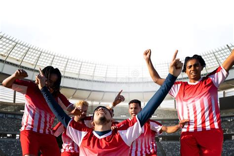Team Of Multiracial Young Soccer Players Celebrating Victory In Stadium