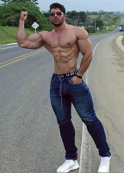 A Man Standing On The Side Of A Road Flexing His Muscles