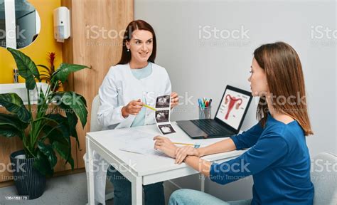 Gynecologist Showing To Woman Ultrasound Of Her Ovaries During Visit To