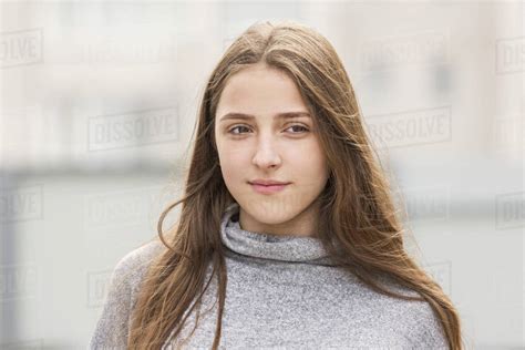 Teenage Girl With Long Brown Hair Standing Outdoors Stock Photo