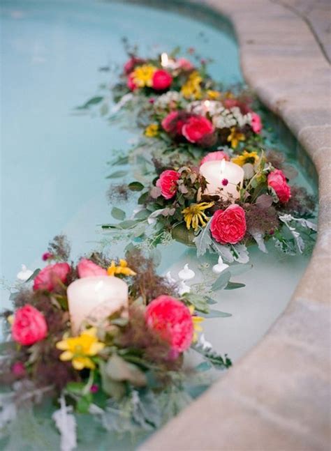 Bold Flower Decorations With Candles Floating In The Pool Pool