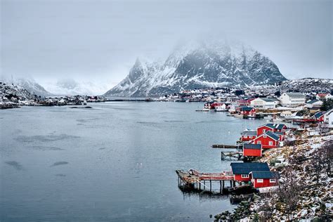 雪が降る冬に赤いロブ家を持つロフォーテン諸島のレーヌ漁村。ロフォーテン諸島、ノルウェーの写真 水 Unsplashの写真