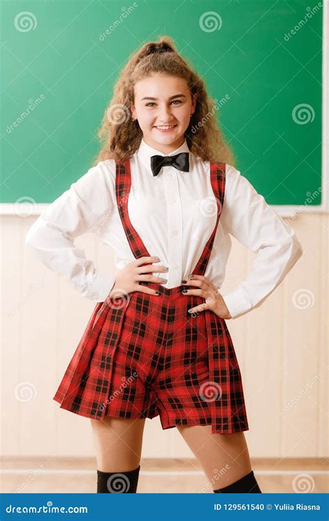 Beautiful Young Schoolgirl In School Uniform Standing On The Background