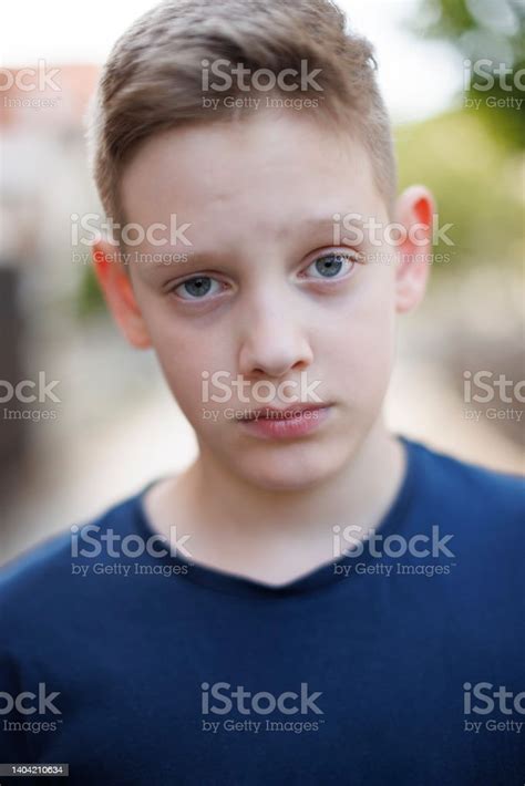 Closeup Portrait Of A Boy With Blue Eyes Seriously Looking At The