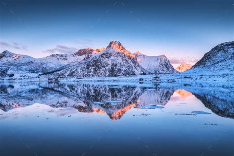 Snowy Mountains And Colorful Sky Reflected In Water At Sunset Stock