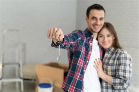 Couple Showing Keys To New Home Happy Young Couple Moving Together In