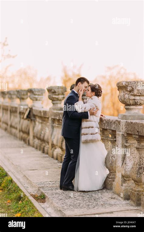 The Sensitive Photo Of The Newlyweds Leaning On The Old Fence The