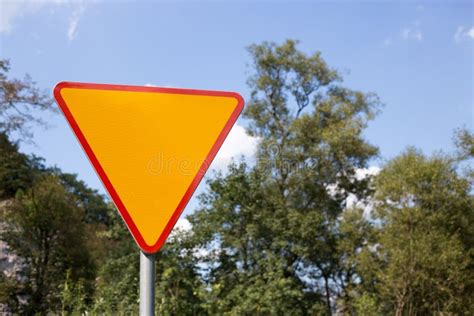 Blank Yellow Triangle Road Sign On The Road Nature Background Stock