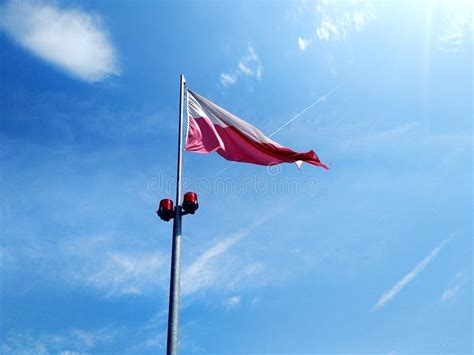 The Polish White Red Flag Develops Against The Blue Sky And White