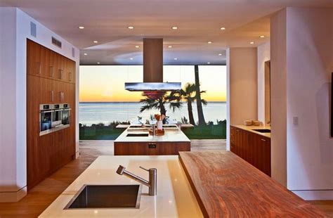 A Kitchen With An Island Counter Sink And Large Window Overlooking The