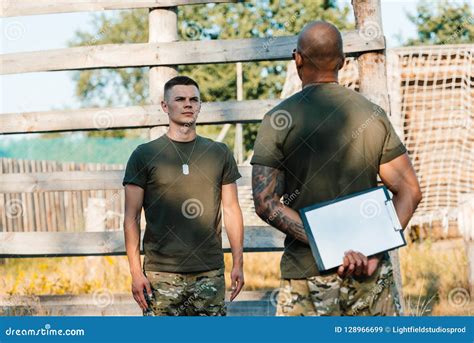 African American Tactical Instructor With Notepad And Young Soldier In