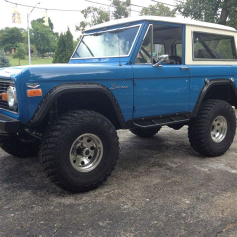 Early Bronco Steel Blue With Huge Tires On Aluminum Rims With Holes